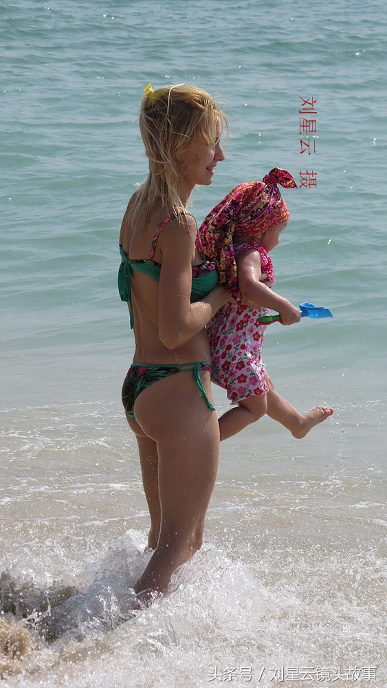 俄罗斯人三亚沙滩享受亲子日光浴好惬意,为人之母的洋妞有苗条的