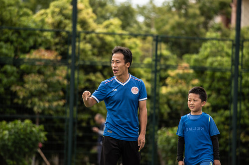 开学上学校踢球,春天到了小朋友们在草地上踢足球