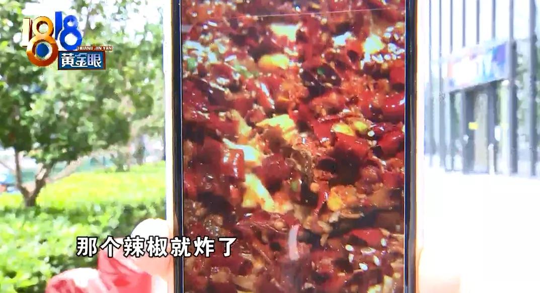 姑娘正要拍烤鱼，店员翻锅，一颗辣椒炸开，热油溅到了脸上