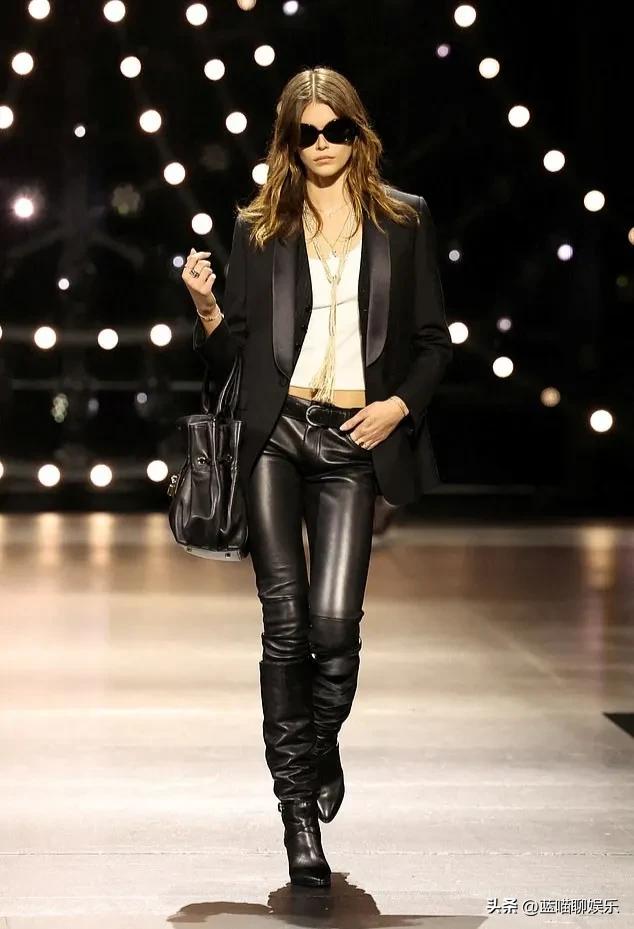 21岁的凯雅·杰柏在家人的支持下，身着一件金色露背迷你裙走秀